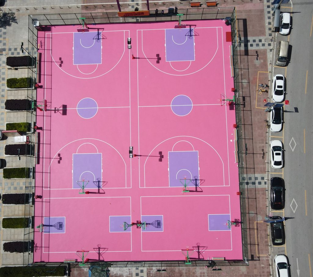 Aerial view of pink silicone PU court systems for multi-sport basketball courts